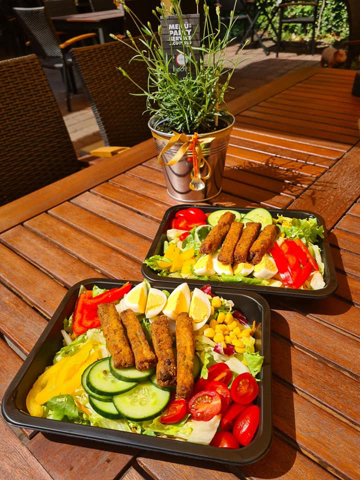 Gemütlicher Imbiss in Cottbus – bunte Salatboxen auf der Terrasse